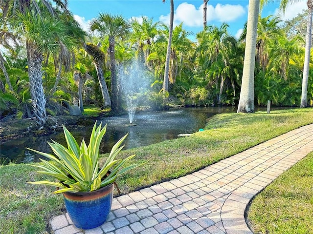 view of community featuring a lawn and a water view