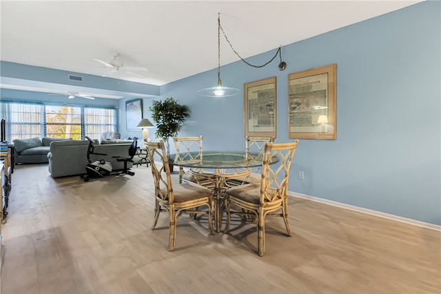 dining space with ceiling fan and light hardwood / wood-style floors