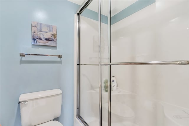 bathroom featuring toilet and an enclosed shower