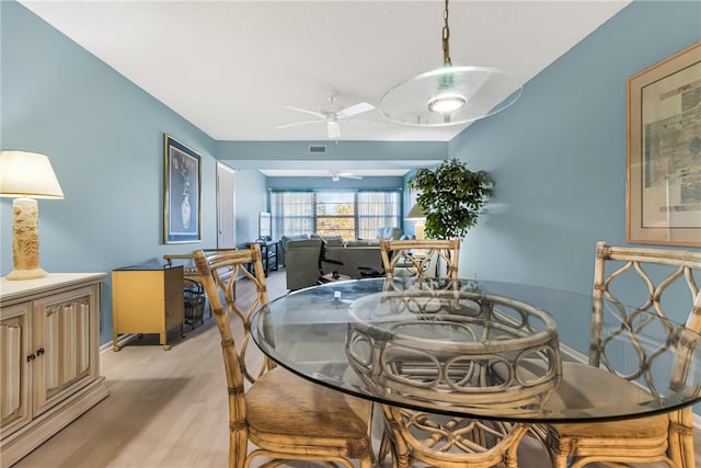 dining area with light hardwood / wood-style floors and ceiling fan