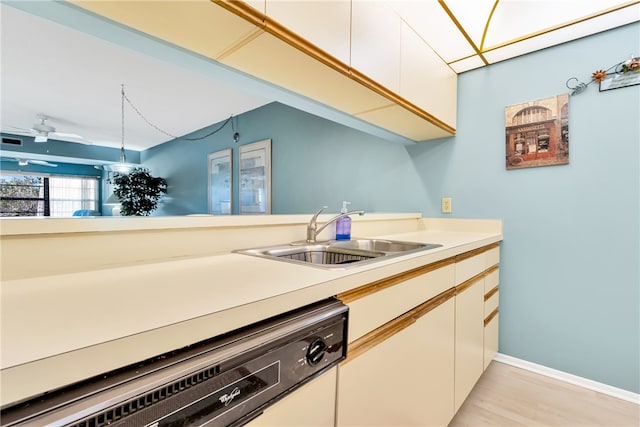 kitchen featuring ceiling fan, white cabinetry, sink, and light hardwood / wood-style flooring