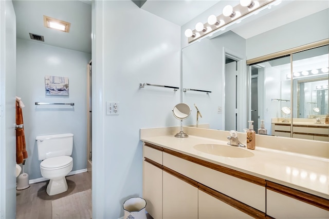 bathroom featuring vanity, toilet, and wood-type flooring