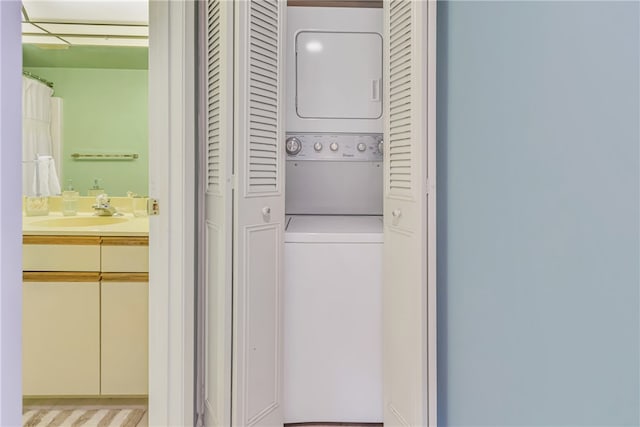 washroom with sink and stacked washer and clothes dryer