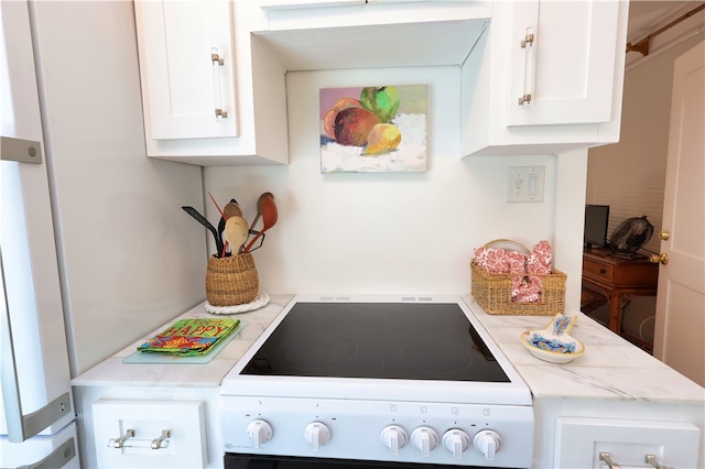 kitchen with stove and white cabinetry