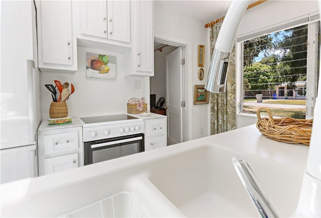 kitchen with range with electric cooktop and white cabinetry