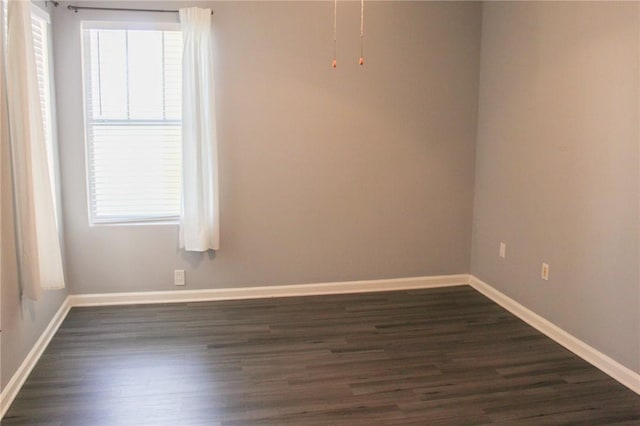 unfurnished room with baseboards, plenty of natural light, and dark wood finished floors