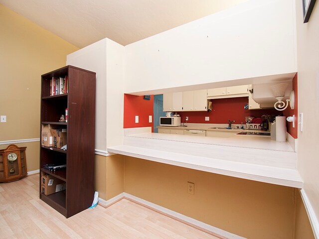 kitchen with sink, light wood-type flooring, and cream cabinets