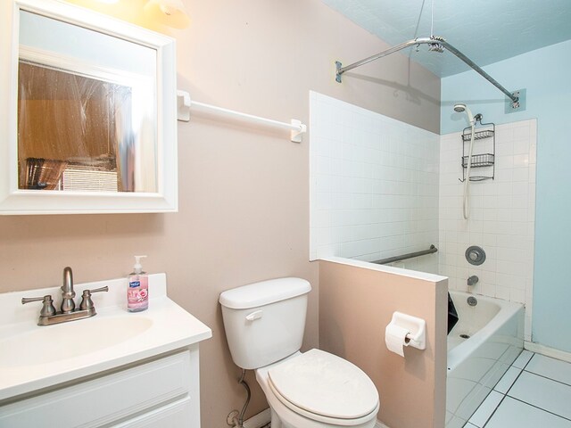 full bathroom with toilet, tiled shower / bath combo, vanity, and tile patterned flooring