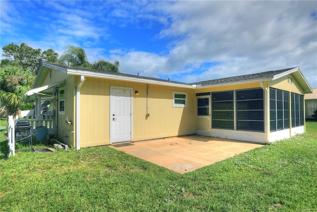 back of property featuring a patio area, a lawn, and a sunroom