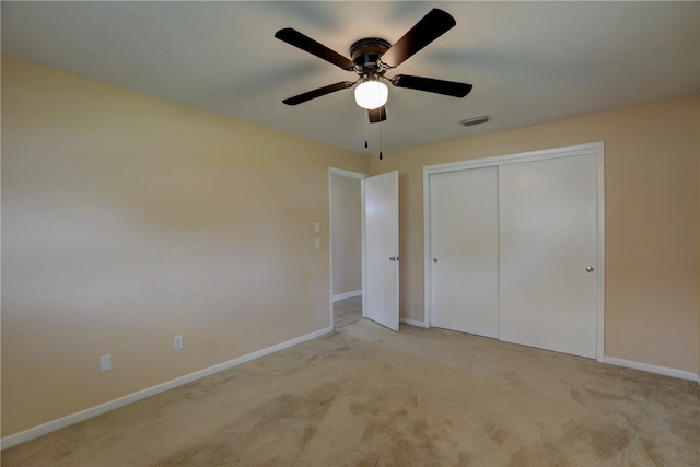 unfurnished bedroom with ceiling fan, a closet, and light colored carpet