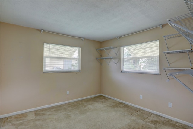 carpeted empty room with a textured ceiling