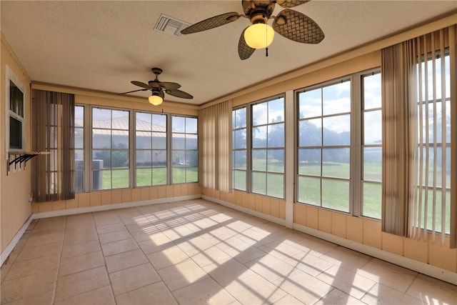 unfurnished sunroom featuring ceiling fan and plenty of natural light