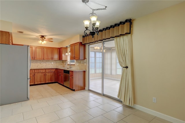 kitchen with sink, appliances with stainless steel finishes, ceiling fan with notable chandelier, backsplash, and decorative light fixtures