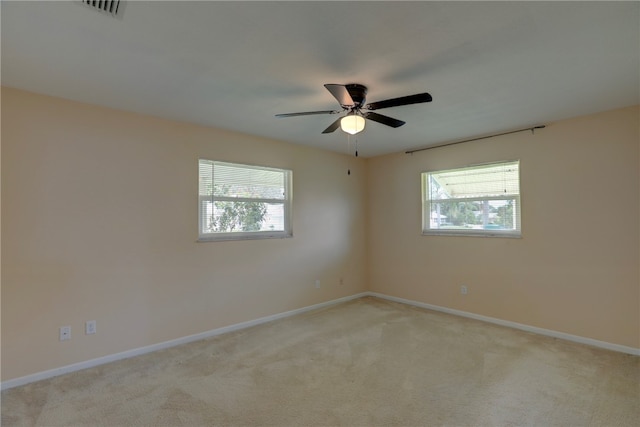 spare room with ceiling fan and light carpet