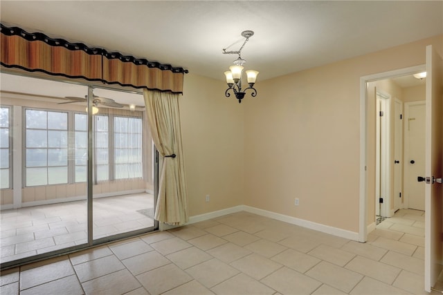 empty room with light tile patterned flooring and ceiling fan with notable chandelier