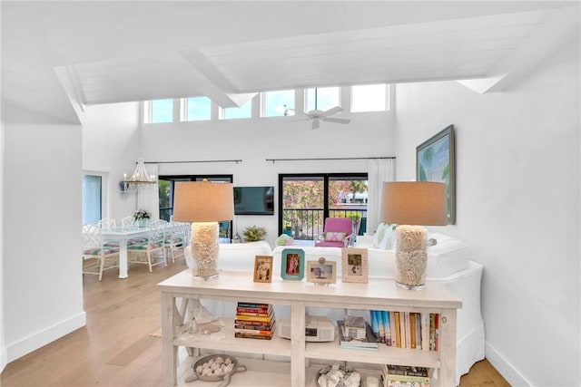 interior space featuring ceiling fan, hardwood / wood-style floors, and a towering ceiling