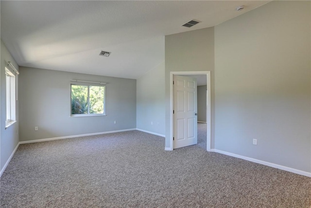 empty room featuring visible vents, baseboards, carpet, and vaulted ceiling