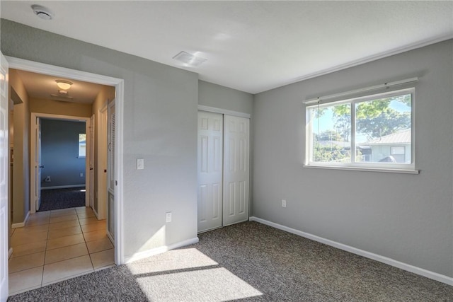 unfurnished bedroom with carpet flooring, baseboards, and a closet