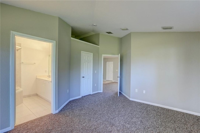 unfurnished bedroom with visible vents, connected bathroom, baseboards, and carpet