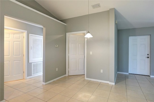 spare room with visible vents, lofted ceiling, baseboards, and light tile patterned flooring