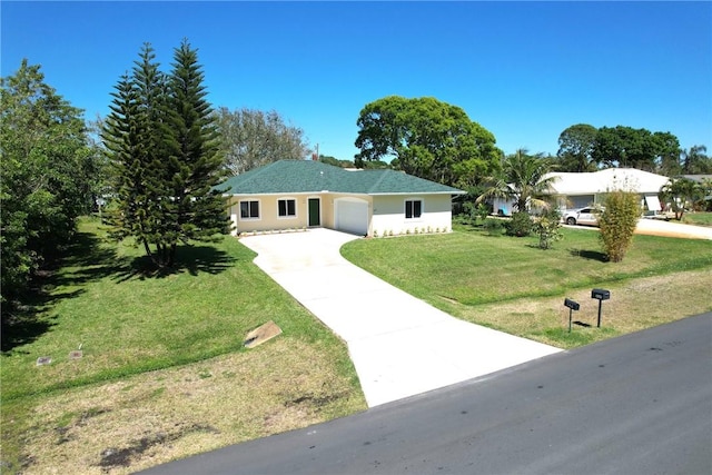 ranch-style home with concrete driveway, a garage, a front yard, and stucco siding