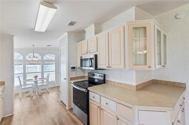 1218 Chipewa Dr, Sebastian, FL 32976 - kitchen featuring appliances with stainless steel finishes, ornamental molding, a chandelier, light wood-style flooring, and light countertops