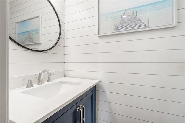 bathroom featuring vanity and wooden walls