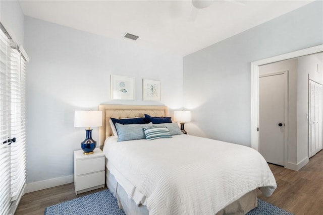 bedroom featuring visible vents, baseboards, wood finished floors, and a ceiling fan