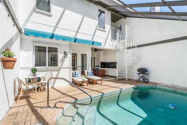 outdoor pool featuring a patio area, french doors, and stairs