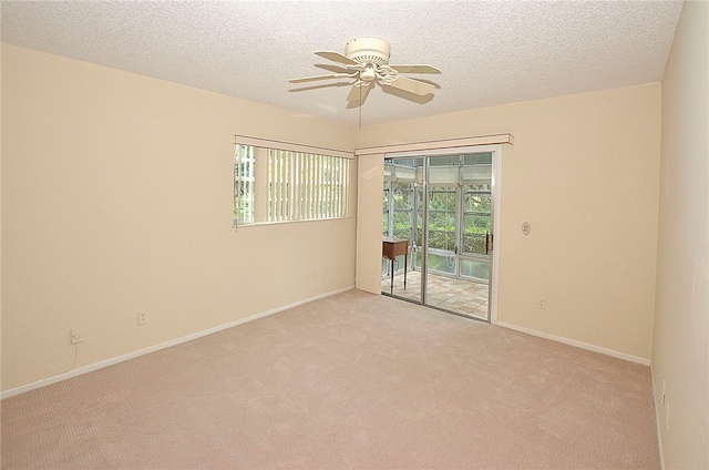 carpeted spare room with a textured ceiling and ceiling fan