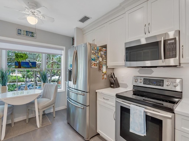 133 E Park Shores Cir Unit 8E, Vero Beach, FL 32963 - kitchen with stainless steel appliances, white cabinets, backsplash, and light tile patterned floors