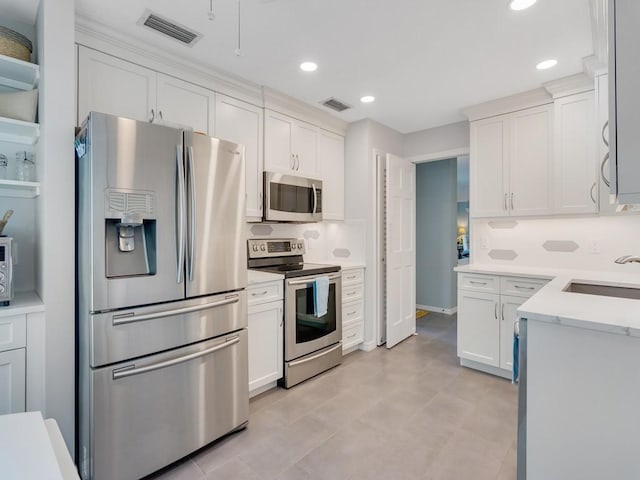 133 E Park Shores Cir Unit 8E, Vero Beach, FL 32963 - kitchen with stainless steel appliances, a sink, white cabinets, light countertops, and recessed lighting