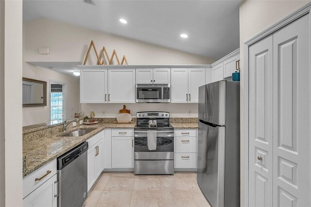 1360 18th Ave SW, Vero Beach, FL 32962 - kitchen featuring appliances with stainless steel finishes, a sink, lofted ceiling, light stone countertops, and white cabinetry