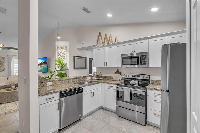 1360 18th Ave SW, Vero Beach, FL 32962 - kitchen featuring appliances with stainless steel finishes, a sink, vaulted ceiling, white cabinets, and light stone counters