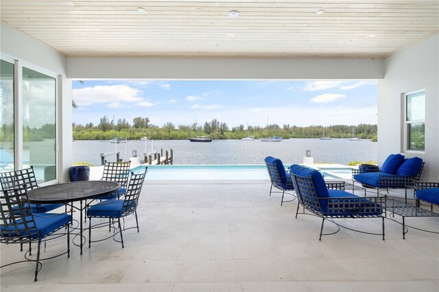 view of swimming pool with a water view and a patio area