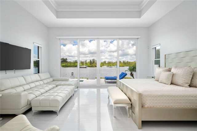 bedroom with access to outside and a raised ceiling