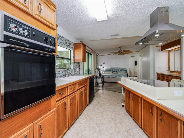 kitchen with sink, island range hood, black appliances, ceiling fan, and backsplash