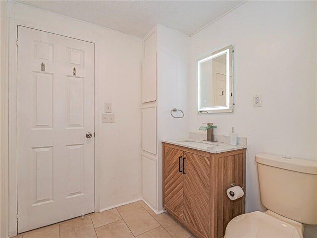 bathroom with vanity, toilet, and tile patterned flooring