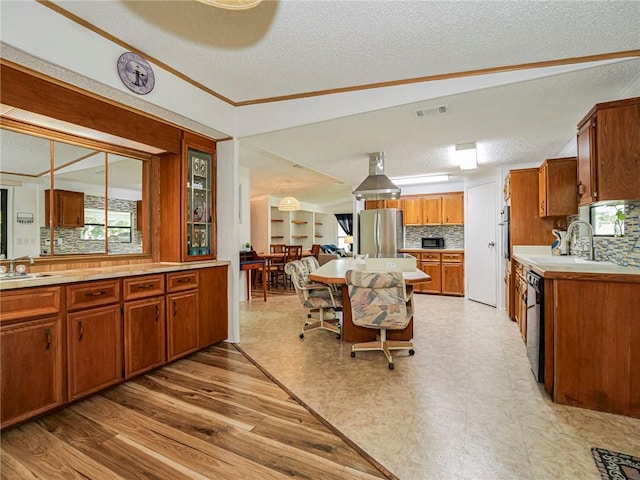 kitchen featuring dishwasher, sink, stainless steel fridge, and backsplash