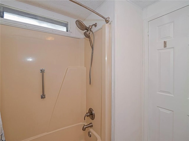 bathroom with bathing tub / shower combination and a textured ceiling