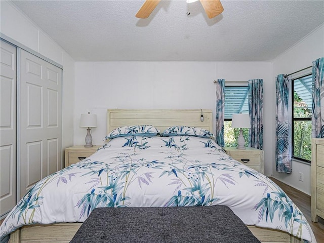 bedroom with a closet, ceiling fan, hardwood / wood-style floors, and a textured ceiling