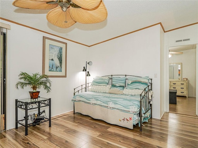 bedroom with hardwood / wood-style floors, crown molding, a textured ceiling, and ceiling fan