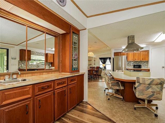 kitchen with sink, island range hood, stainless steel fridge, and a textured ceiling