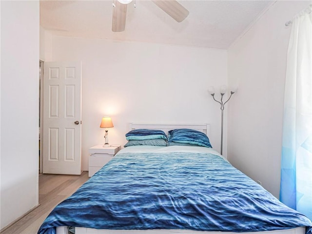 bedroom with light hardwood / wood-style floors and ceiling fan