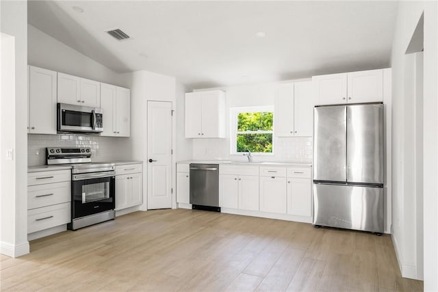 kitchen featuring a sink, stainless steel appliances, visible vents, and light countertops