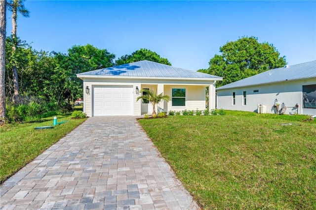 view of front of home featuring decorative driveway, a garage, metal roof, and a front lawn