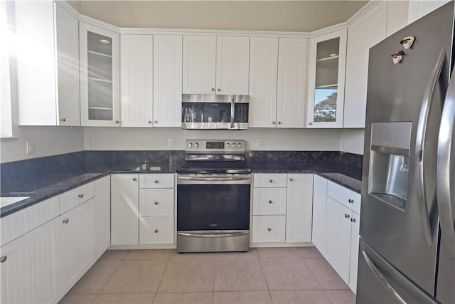 kitchen featuring stainless steel appliances, white cabinets, and glass insert cabinets