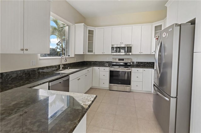 kitchen with glass insert cabinets, appliances with stainless steel finishes, and white cabinets