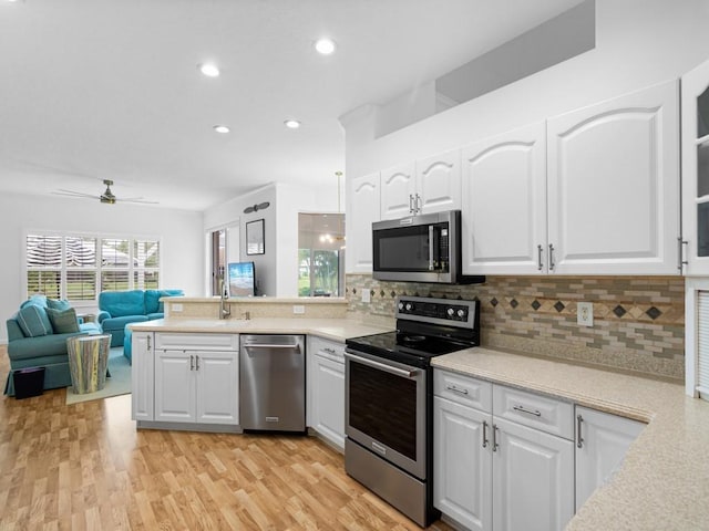 kitchen with white cabinets, backsplash, ceiling fan, and stainless steel appliances