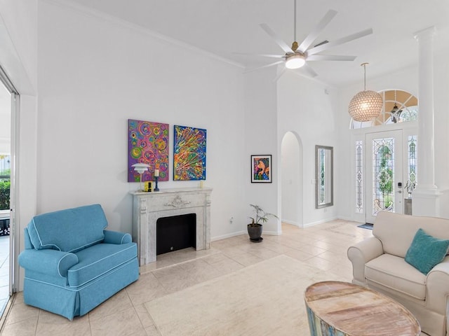 tiled living room featuring ceiling fan, a fireplace, and a high ceiling